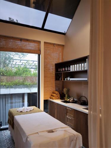 a bedroom with a bed and a kitchen with a window at Mai's Boutique in Da Nang