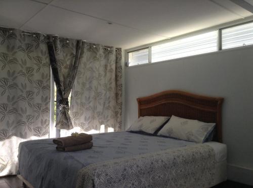 1 dormitorio con 1 cama y 2 ventanas en Studio Apartment with Seaview, en Airlie Beach