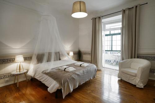 1 dormitorio con 1 cama, 1 silla y 1 ventana en 1924, en Lisboa