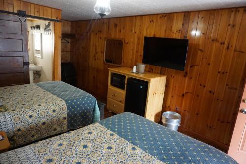 um quarto de hotel com duas camas e uma televisão de ecrã plano em Marshall's Creek Rest Motel em Gatlinburg