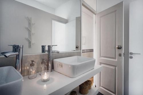 a white bathroom with a sink and a mirror at 1924 in Lisbon