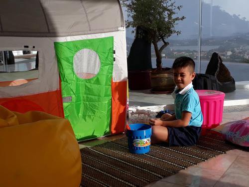a young boy sitting in front of a tent at Best world vision in Chaweng