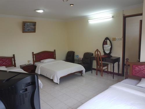 a bedroom with two beds and a flat screen tv at Hung Vuong Hotel in Pleiku
