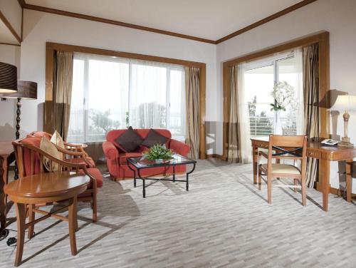 a living room with a red couch and a table at Dorsett Grand Labuan in Labuan