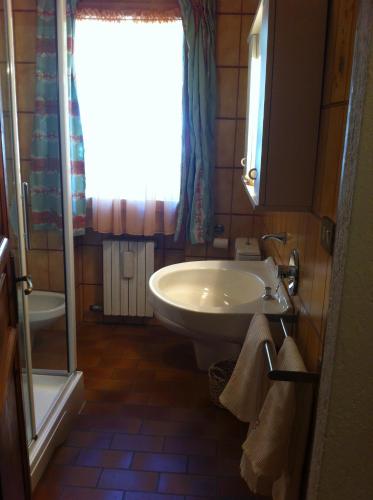 a bathroom with a sink and a toilet and a window at Le Lierre in Châtillon