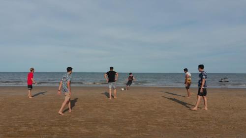 a group of people playing with a frisbee on the beach at Talay Hotel and Villa Cha-am in Cha Am