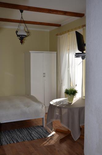 a bedroom with a bed and a table and a window at Papli Villade Apartment in Pärnu