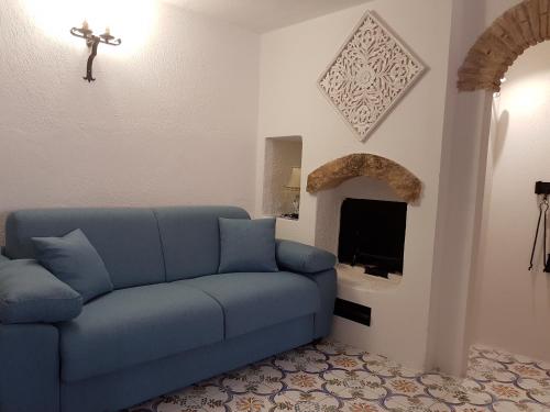 een blauwe bank in een woonkamer met een open haard bij Il Nido 3 in San Vito lo Capo