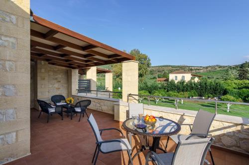 a patio with tables and chairs on a balcony at Villas Kalives in Kalyves