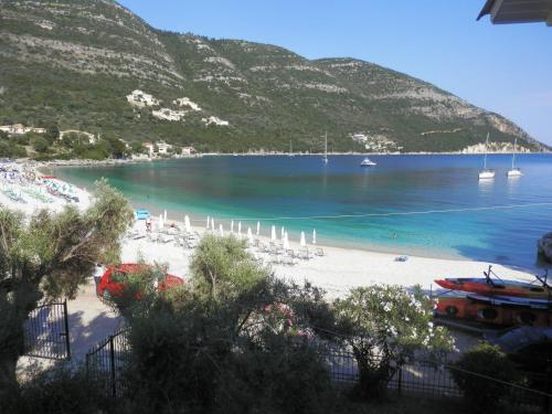 a beach with chairs and boats in the water at Sea Pebble Studios in Mikros Gialos