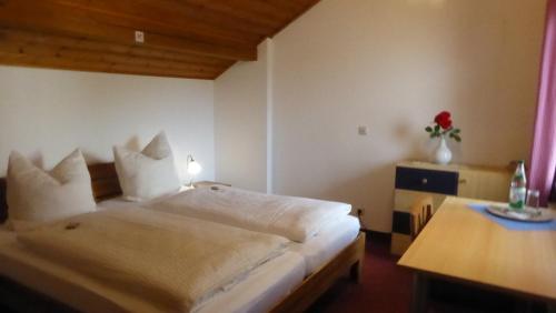 シュロベンハウゼンにあるHaus Rosmarinのベッドルーム(大きな白いベッド1台、テーブル付)