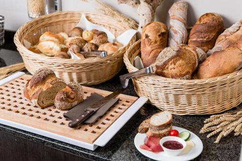 a table with baskets of bread and baskets of pastries at Hotel Schloss Hünigen in Konolfingen