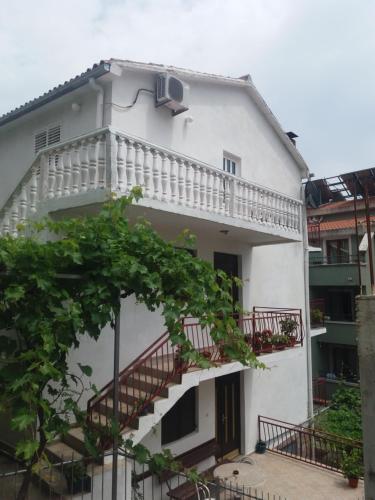 a white building with a balcony and a staircase at Apartments MM Budva in Budva