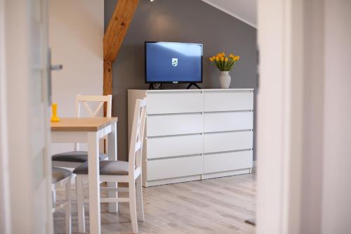 a room with a table and a tv on a dresser at Apartamenty "Kotlina" in Bystrzyca Kłodzka