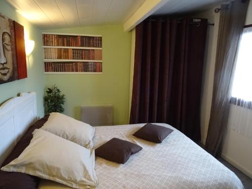 une chambre avec un lit avec deux oreillers dessus dans l'établissement au coeur de la campagne, à Donzac