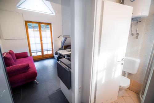 ein Wohnzimmer mit einem roten Sofa und einer Küche in der Unterkunft Golf apartment with SPA tickets discount in Moravske-Toplice