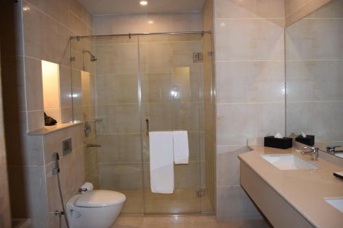 a bathroom with a toilet, sink, and shower at Defence Raya Golf & Country Club in Lahore