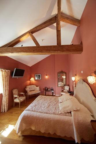 a bedroom with pink walls and a large bed at Olivier Leflaive Hôtel Restaurants in Puligny-Montrachet
