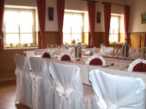 a conference room with white tables and chairs and windows at Hotel Auerhahn in Grevenkrug