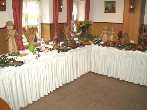 a long white table with flowers on it at Hotel Auerhahn in Grevenkrug