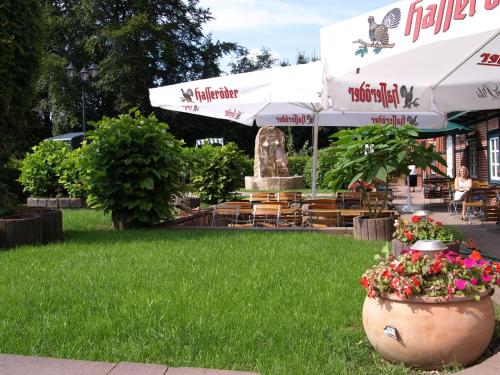a patio with a fountain and flowers in a park at Hotel Auerhahn in Grevenkrug