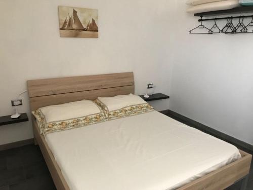 una camera da letto con un grande letto con lenzuola bianche di Appartamento Rosmarino a Buggerru