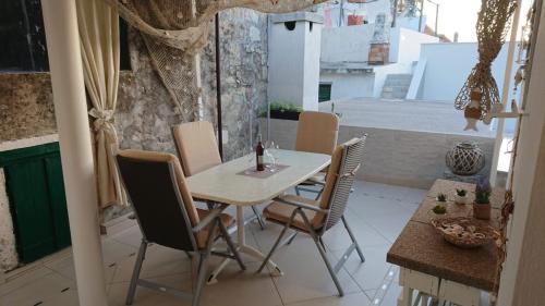 a table and chairs on a patio with a view of a building at Apartman Mara in Hvar