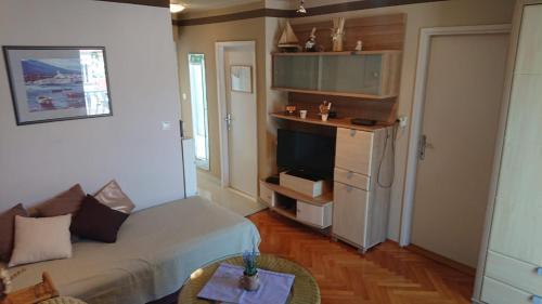 a small living room with a bed and a fireplace at Apartman Mara in Hvar