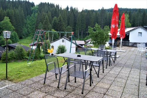 a group of tables and chairs with a playground at Penzion Sumavacek in Bayerisch Eisenstein
