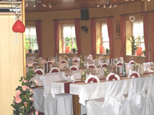 a set of tables in a room with white table cloth at Hotel Auerhahn in Grevenkrug
