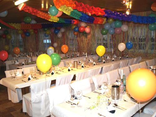 a banquet hall with tables with balloons on the ceiling at Hotel Auerhahn in Grevenkrug