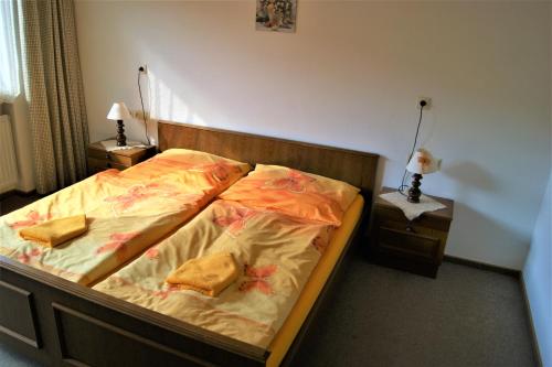 a bedroom with a bed with two pillows on it at Penzion Sumavacek in Bayerisch Eisenstein