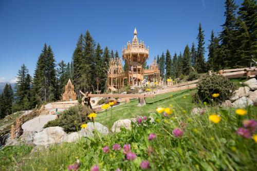 a view of a castle with a field of flowers at Ursprung Panorama Hotel Königsleiten in Königsleiten