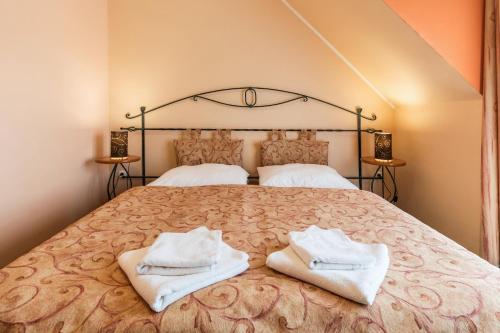 a bedroom with a large bed with towels on it at Kyjovský pivovar - hotel, restaurace, pivní lázně in Kyjov