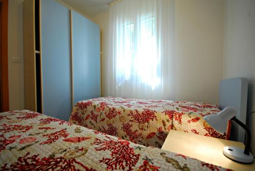 una camera d'albergo con due letti e una finestra di Villa Palme a Lignano Sabbiadoro