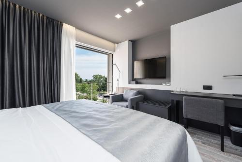 Habitación de hotel con cama, escritorio y ventana en Artis accommodation, en Zadar