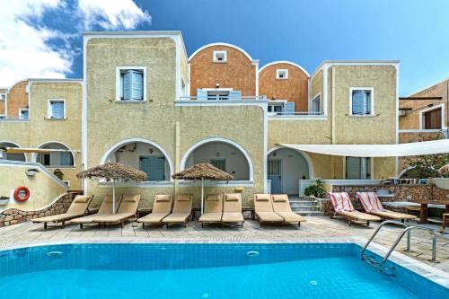 a resort with a swimming pool and chairs and a building at Sellada Apartments in Kamari