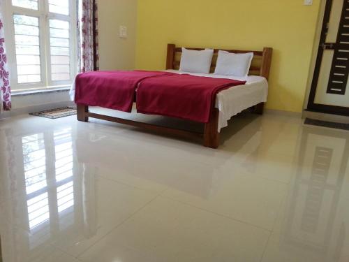 a bedroom with a bed with a red blanket at Maharaja Home Stay Panhala in Panhāla