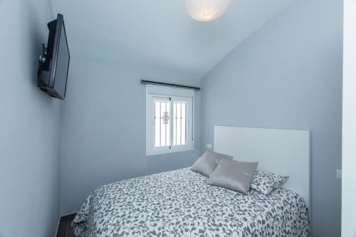 a blue bedroom with a bed and a television at Casa Alma in Marbella