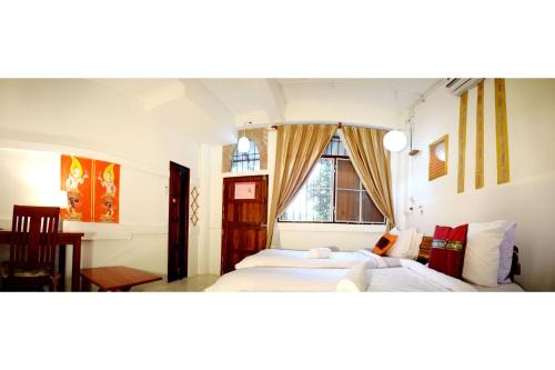 um quarto com 2 camas e uma janela em Villa Scĕnns em Sangkhla Buri