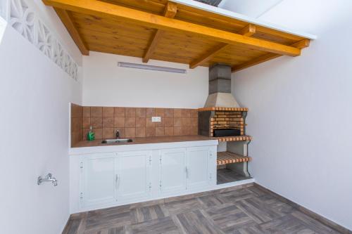 a kitchen with white cabinets and a wood stove at Casa Alma in Marbella