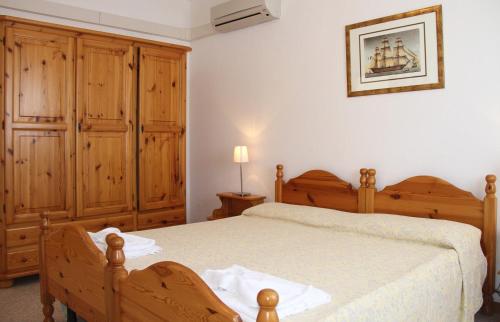 Gardenia Casa Vacanze في ألغيرو: غرفة نوم بسرير كبير ودواليب خشبية