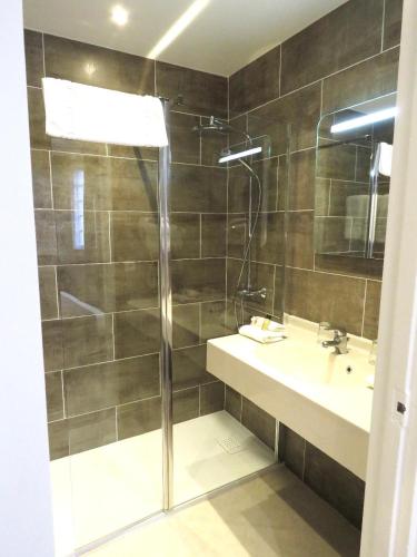 a bathroom with a shower and a sink at Grand Hôtel de L'Espérance in Lisieux