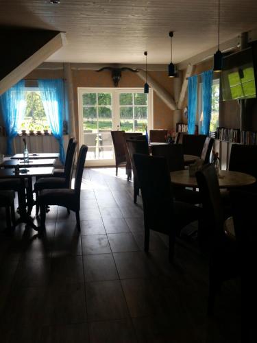 a dining room with tables and chairs and a window at Ranna Villa Farm in Küdema