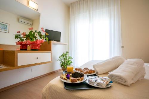una stanza con due piatti di cibo su un letto di Hotel Ridolfi a Milano Marittima