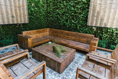 a wooden bench with a plant on it next to two chairs at Praktik Vinoteca in Barcelona