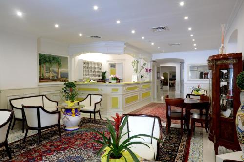 sala de estar con sillas, mesa y comedor en Hotel Astoria Sorrento en Sorrento