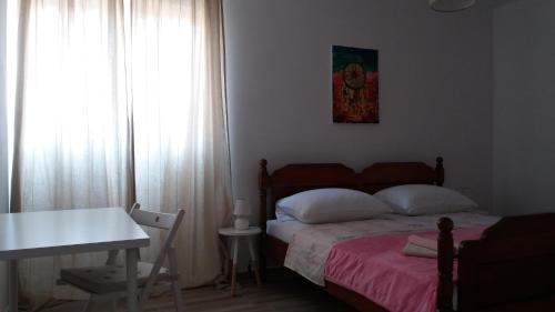 a bedroom with a bed and a table and a window at Flamingo in Šibenik