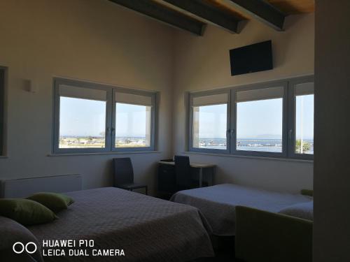 a bedroom with two beds and windows with a view of an airport at B&B Brezza Delle Egadi in Marsala
