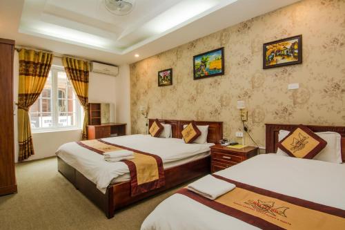 Hanoi Central Backpackers Hostel في هانوي: غرفة فندقية بسريرين ونافذة